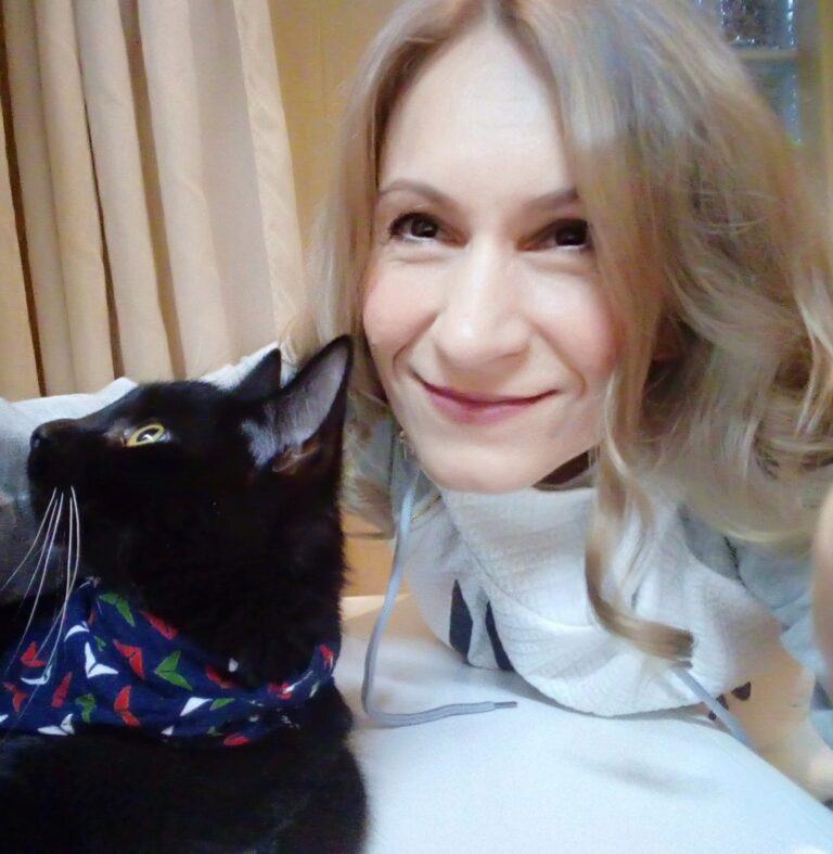 Edit Szóráth smiling cheek to cheek with her black cat